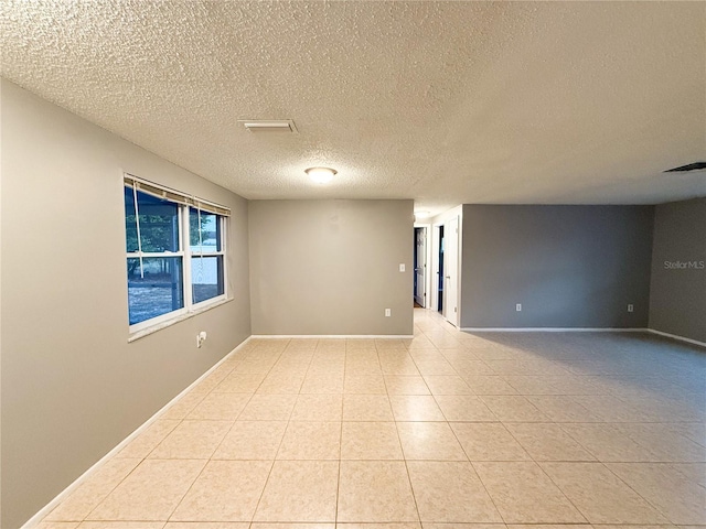 tiled spare room with a textured ceiling