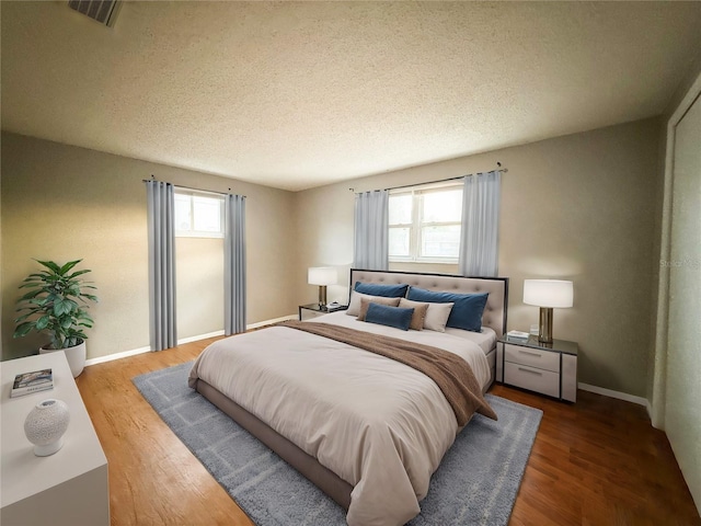 6417 Sutherland Ave, New Port Richey, FL 34653 - bedroom featuring multiple windows, wood finished floors, a textured ceiling, and baseboards