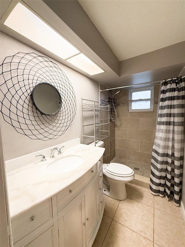 bathroom featuring toilet, vanity, tile patterned floors, and a shower with curtain