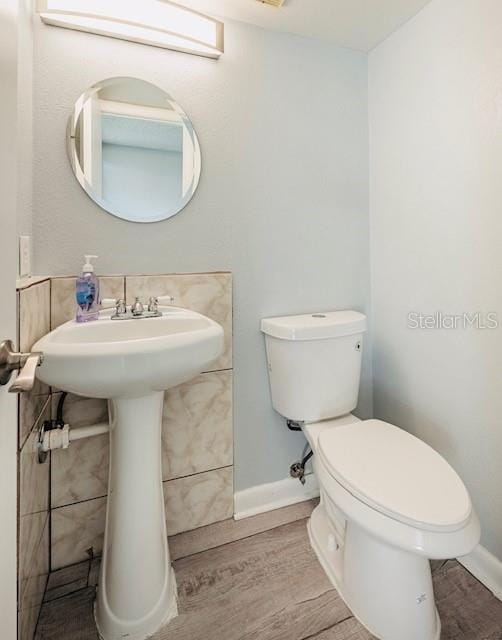 bathroom with sink, toilet, and hardwood / wood-style floors