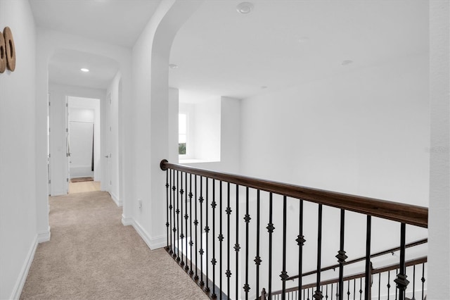 hallway featuring light colored carpet