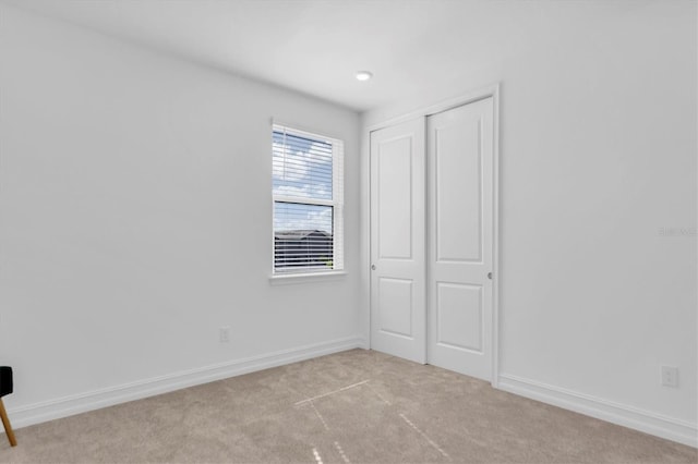 unfurnished bedroom featuring light carpet