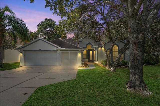 view of front of home with a garage and a yard