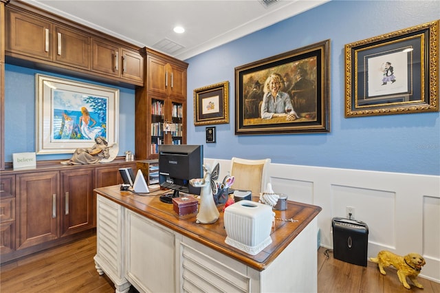 home office with crown molding and light hardwood / wood-style flooring