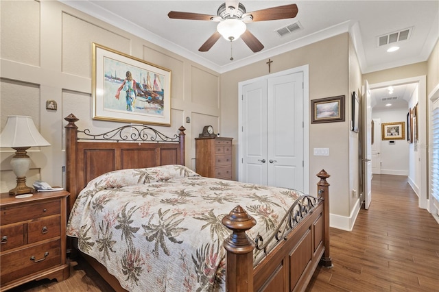 bedroom with crown molding, wood-type flooring, a closet, and ceiling fan