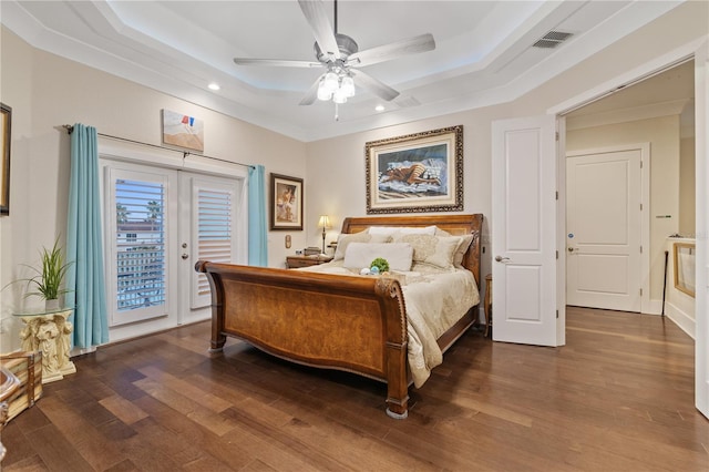 bedroom with ornamental molding, access to outside, ceiling fan, a tray ceiling, and dark wood-type flooring