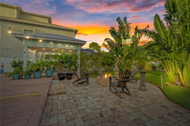 patio terrace at dusk featuring an outdoor fire pit