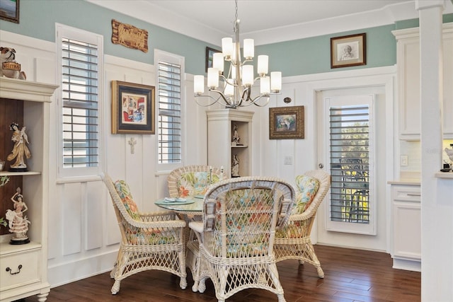 dining room featuring crown molding, dark hardwood / wood-style floors, and an inviting chandelier