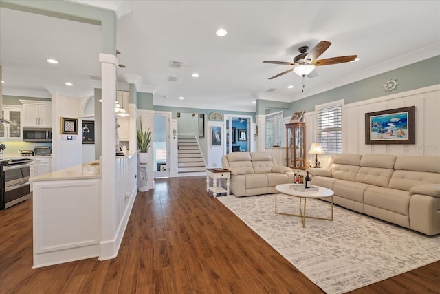 living room with ceiling fan, ornamental molding, and dark hardwood / wood-style flooring