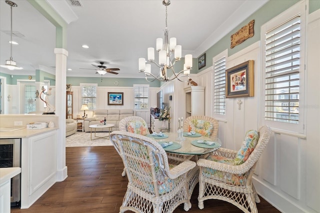 dining area with decorative columns, crown molding, dark hardwood / wood-style floors, and a wealth of natural light