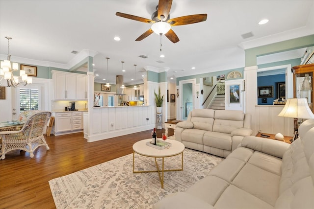 living room featuring crown molding, ceiling fan with notable chandelier, and hardwood / wood-style floors