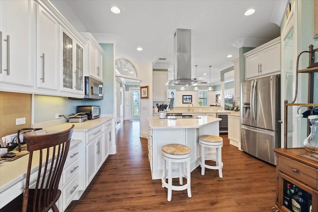 kitchen with a breakfast bar, hanging light fixtures, a center island, kitchen peninsula, and stainless steel appliances