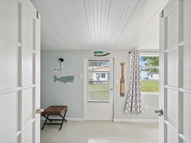 entryway with wood ceiling and light tile patterned floors