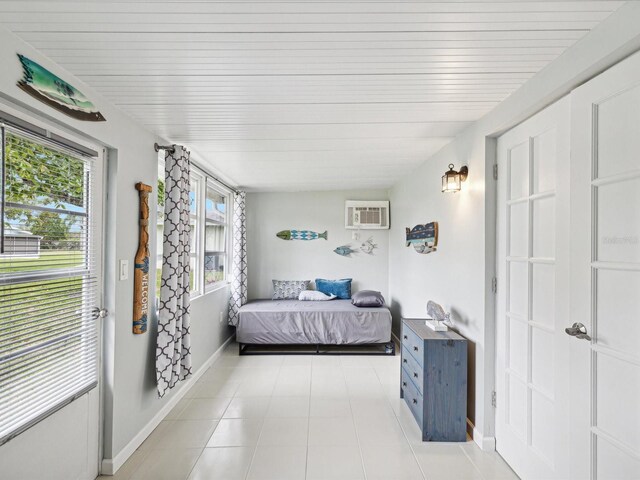 tiled bedroom with multiple windows and a wall mounted air conditioner