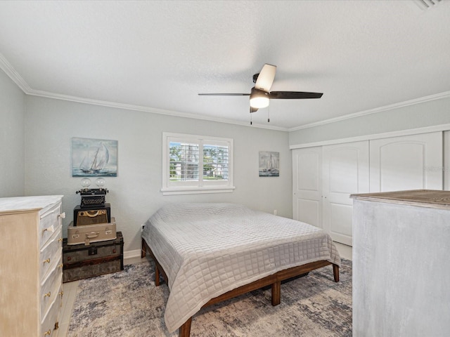 bedroom with ceiling fan, a closet, light wood-type flooring, and ornamental molding