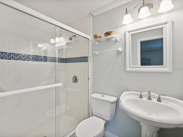 bathroom with a textured ceiling, toilet, an enclosed shower, and sink