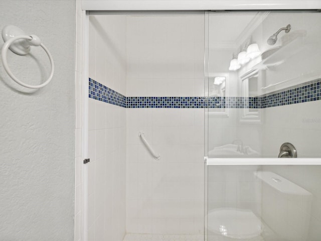 bathroom featuring a shower with door