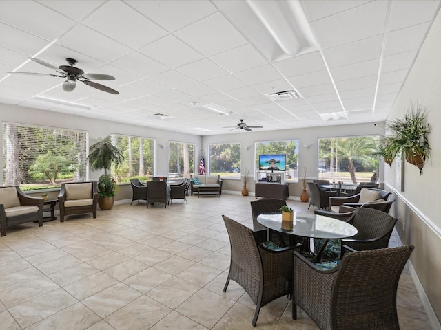 sunroom with a drop ceiling, a wealth of natural light, and ceiling fan