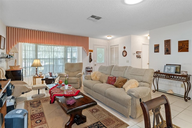 living room with a textured ceiling and light tile patterned flooring