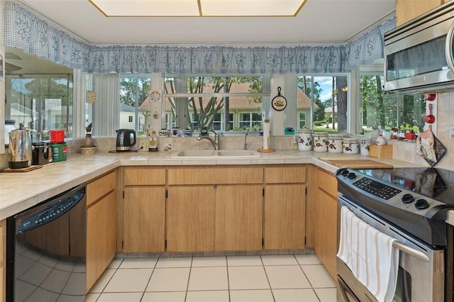 kitchen featuring appliances with stainless steel finishes, sink, and light tile patterned flooring