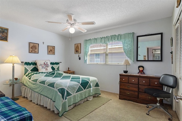 bedroom featuring a closet, a textured ceiling, light carpet, and ceiling fan