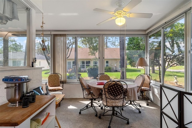 sunroom / solarium with a healthy amount of sunlight and ceiling fan