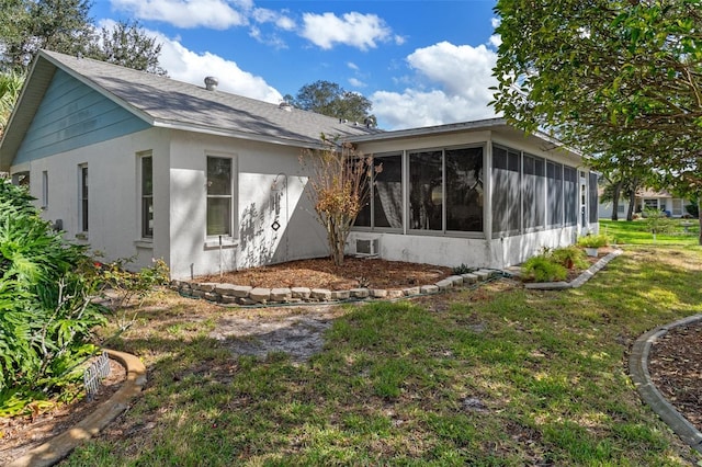 back of property with a sunroom and a yard