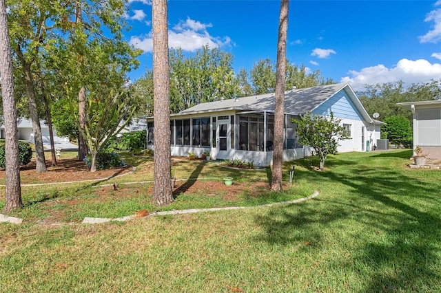 back of house with a sunroom and a lawn