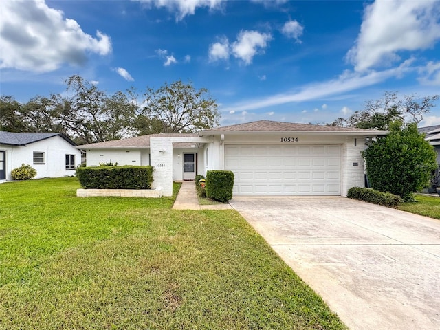 ranch-style home featuring a front lawn and a garage