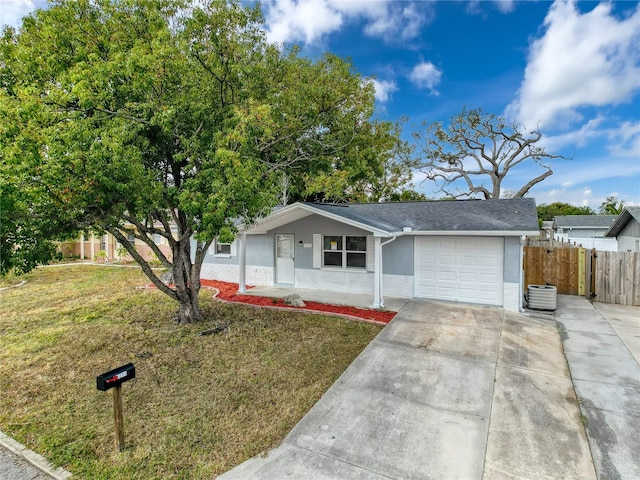 ranch-style house featuring a front lawn, a garage, and cooling unit