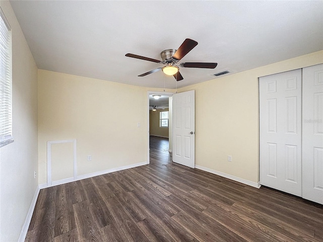 unfurnished bedroom with ceiling fan, dark hardwood / wood-style floors, and a closet