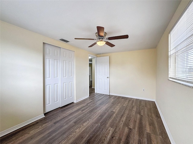 unfurnished bedroom featuring dark hardwood / wood-style flooring, a closet, and ceiling fan