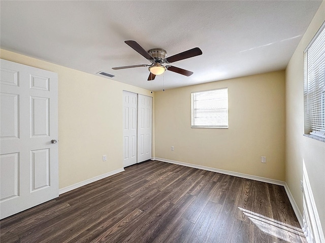 unfurnished bedroom featuring a closet, a textured ceiling, ceiling fan, and dark hardwood / wood-style floors