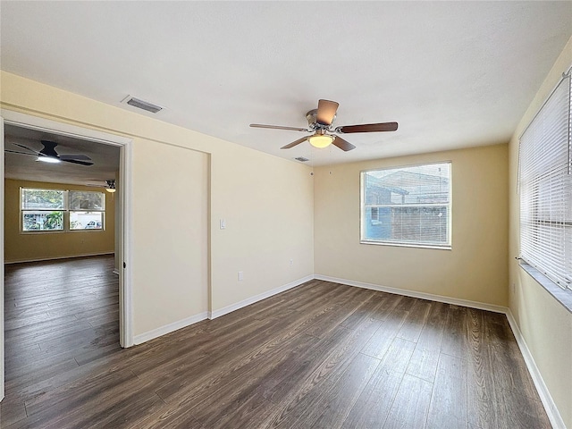 unfurnished room with dark wood-type flooring and ceiling fan