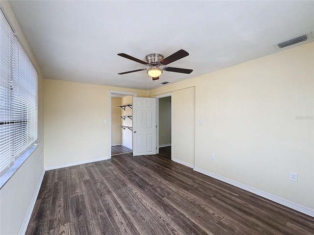 empty room featuring dark wood-type flooring and ceiling fan