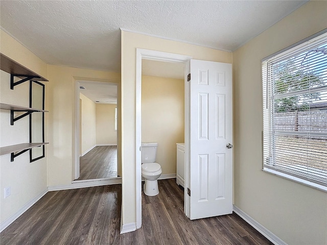 bathroom featuring toilet, hardwood / wood-style floors, and a textured ceiling