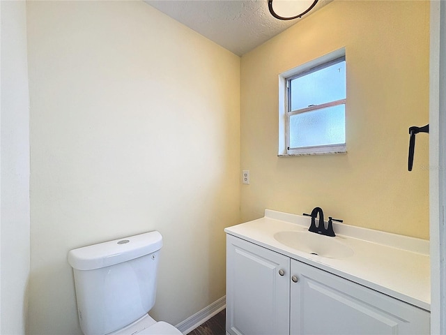 bathroom with toilet, vanity, and a textured ceiling