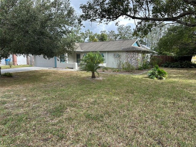 8353 Forest Oaks Blvd, Spring Hill, FL 34606 - view of front of home with driveway, an attached garage, and stucco siding