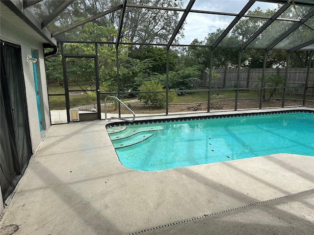 view of pool featuring glass enclosure and a patio area