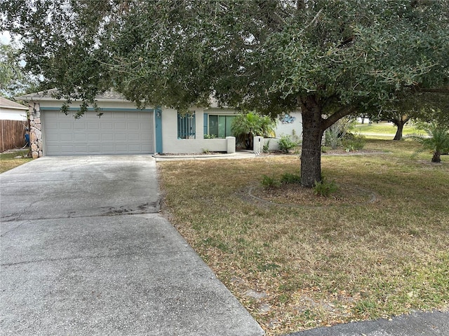 view of property hidden behind natural elements featuring a front yard and a garage