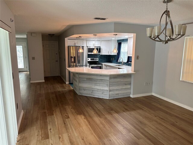 8353 Forest Oaks Blvd, Spring Hill, FL 34606 - kitchen with appliances with stainless steel finishes, a sink, a chandelier, white cabinetry, and baseboards
