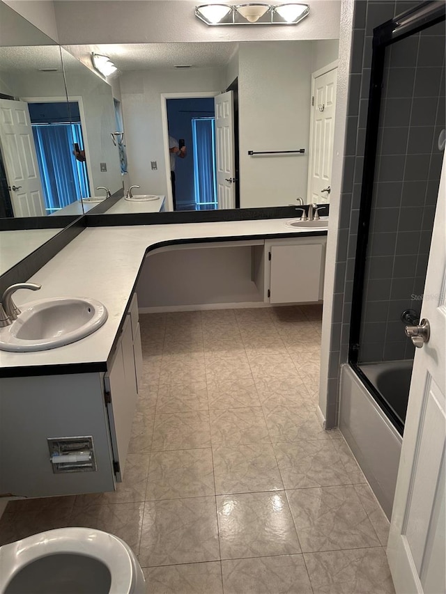 bathroom featuring combined bath / shower with glass door and vanity