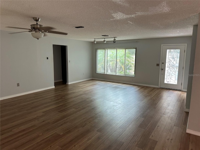 empty room featuring dark wood-type flooring, ceiling fan, and a textured ceiling