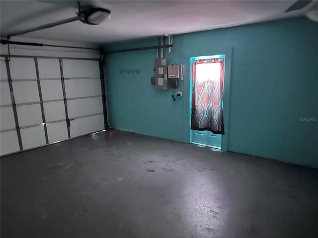 garage with electric panel and a garage door opener