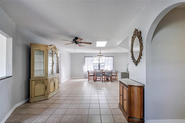 interior space featuring a skylight, a textured ceiling, and ceiling fan