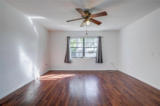 empty room with ceiling fan and dark hardwood / wood-style flooring