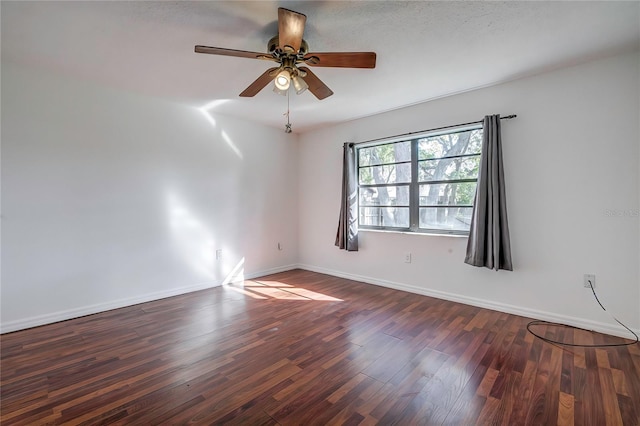 empty room with dark wood-type flooring and ceiling fan