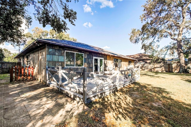 rear view of house featuring a lawn and a wooden deck