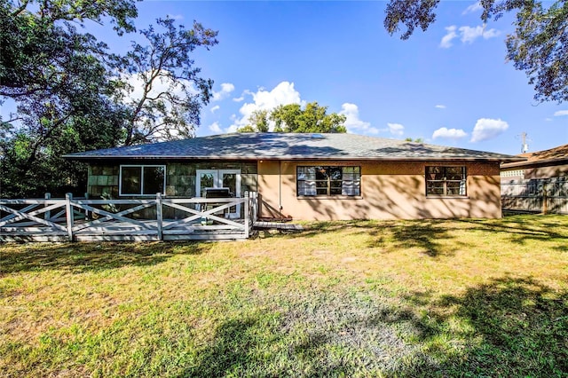 back of house with a lawn and a deck