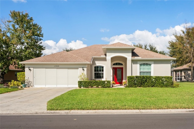 mediterranean / spanish house featuring a front yard and a garage